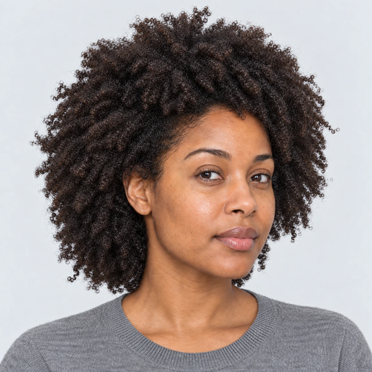 Cheveux crépus aux boucles définies, illustration du rituel sur les longueurs